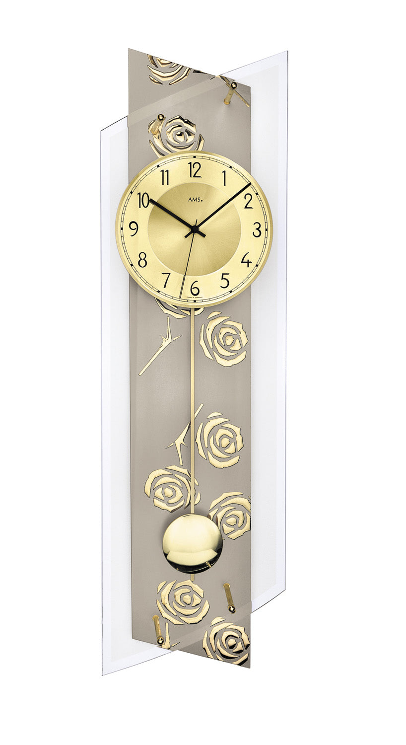 Väggur med pendel, guldfärgad urtavla och rosenornament i en silverfärgad ram