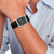 Herrenarmbanduhr am Handgelenk, schwarzes Lederarmband und dunkles Zifferblatt