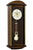 Wall clock with dark wood case and round dial; visible pendulum