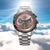 Herrenarmbanduhr mit silberfarbenem Edelstahlarmband und braunem Chronograph-Zifferblatt.