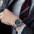 Citizen Armbanduhr am Handgelenk mit blauem Zifferblatt und Metallarmband