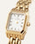 Rechteckige goldene Armbanduhr mit weißem Zifferblatt, römischen Ziffern und Krone