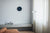 Kleine runde Wanduhr mit dunkelblauem Zifferblatt an der Wand