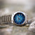 Herrenarmbanduhr mit blauem Zifferblatt auf silbernem Edelstahlband, seitliche Ansicht