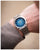 Herrenarmbanduhr am Handgelenk: blaues Zifferblatt und silbernes Metallband mit Datum