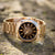 Casio Edifice Uhr in Seitenansicht auf Steinen, goldfarbenes Metallband, schwarzes Zifferblatt