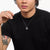 Silver necklace with dragon pendant, pendant centered on black shirt