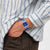 Swatch Armbanduhr am Handgelenk: transparentes Quadratgehäuse, blaues Zifferblatt