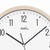 Close-up of wall clock with beige border and white face, black numbers