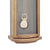 Wall clock pendulum with bell and ornaments against a blue-gray background in a wooden frame