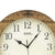 Wanduhr mit nussbaumfarbenem Holzrahmen und weißem Zifferblatt, schwarze Zeiger