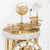 Table clock: Detail of the gold-colored mechanical movement with spheres under a glass dome