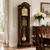 Grandfather clock pendulum with gold-colored ball and chain, within the wooden case frame