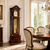Wooden grandfather clock from the side with glass front, dial, and pendulum