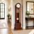 Wooden grandfather clock with glass insert, round dial, golden chime rods, and pendulum ball