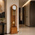 Wooden grandfather clock with round dial, chime rods, and ball on pendulum