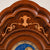 Decorative element on the upper body of the wooden grandfather clock with ornaments