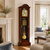 Grandfather clock with gilded movement, pendulum, and golden weights in a dark wood case
