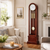Wooden grandfather clock with glass insert, round dial, and pendulum ball