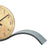 Table clock detail with beige dial and curved stand base in gray
