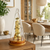Table clock with glass case and gold-colored movement, round wooden base on tabletop