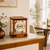 Table clock with cherry wood casing and transparent glass frame; visible clockwork