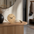 Table clock on wooden console: round dial with black hands and curved base