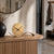 Table clock on wooden base with walnut wood base, round dial and black hands.