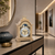 Wooden table clock made of light wood with moon phase arch, round hands, and decorative border