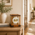 Table clock in cherry wood look with glass windows; visible mechanical movement and Roman numerals