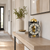 Mechanical table clock on wooden console, round dial with gold-colored skeleton movement
