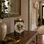 Mechanical table clock with open movement, gold dome, and black frame