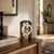 Table clock on wooden surface with open brass movement, Roman numerals, and pendulum weight