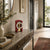 Red table clock in hallway setting on stone slab, dial with pendulum and hands