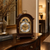 Wooden table clock with moon phase display and gold trim on a wooden base