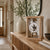 Wooden table clock with open movement, round dial, glass frame on base