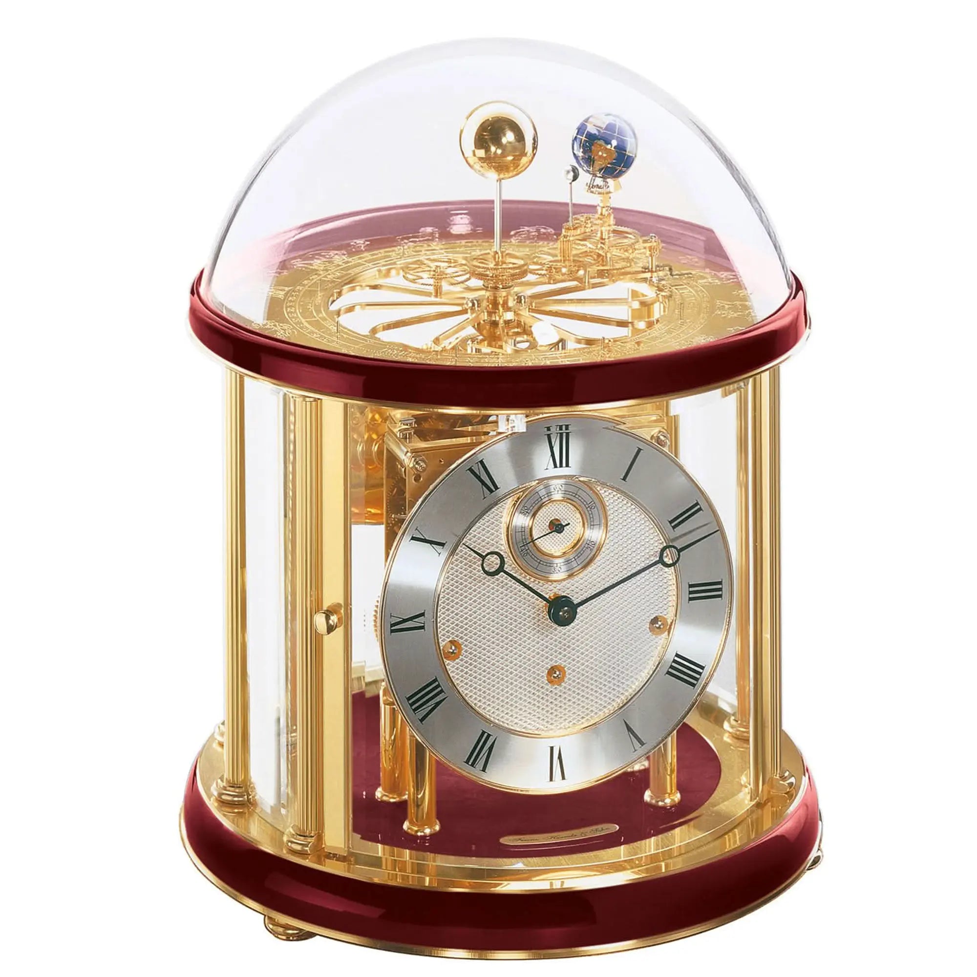 Table clock with gold-colored metal casing and round dial under glass dome