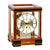 Cherry wood table clock with glass case, gold movement, and Roman numeral dial
