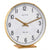 Table clock with white dial, gold hands, and brass frame on wooden base