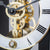Close-up of the clockwork of a dark blue table clock: golden gears and levers