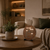 LED word clock with copper-colored round dial and text display, on wooden table