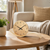 Table clock with beige speckled dial, black hands, and curved brass-look wooden base
