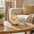 AMS table clock on round wooden table with beige dial and curved base