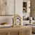 Light wood table clock with round dial, Roman numerals, and moon phase display
