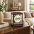 Mahogany table clock with gold columns and round dial with Roman numerals