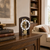 Table clock in dark wood case with large dial, Roman numerals, and brass wheel