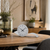 Table clock with gray dial, silver curved base, and black hands
