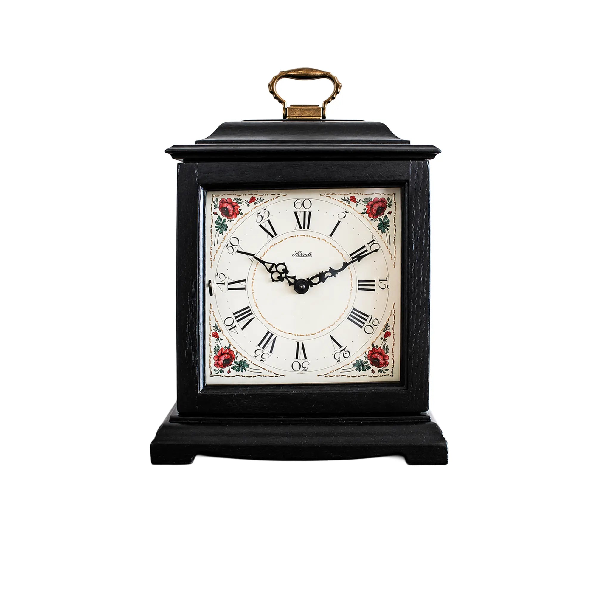 Black table clock with wooden case, gold-colored carrying handle, and floral dial