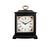 Black table clock with wooden case, gold-colored carrying handle, and floral dial