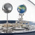 Clockwork under glass dome with globe ornament and metal gears, blue border band